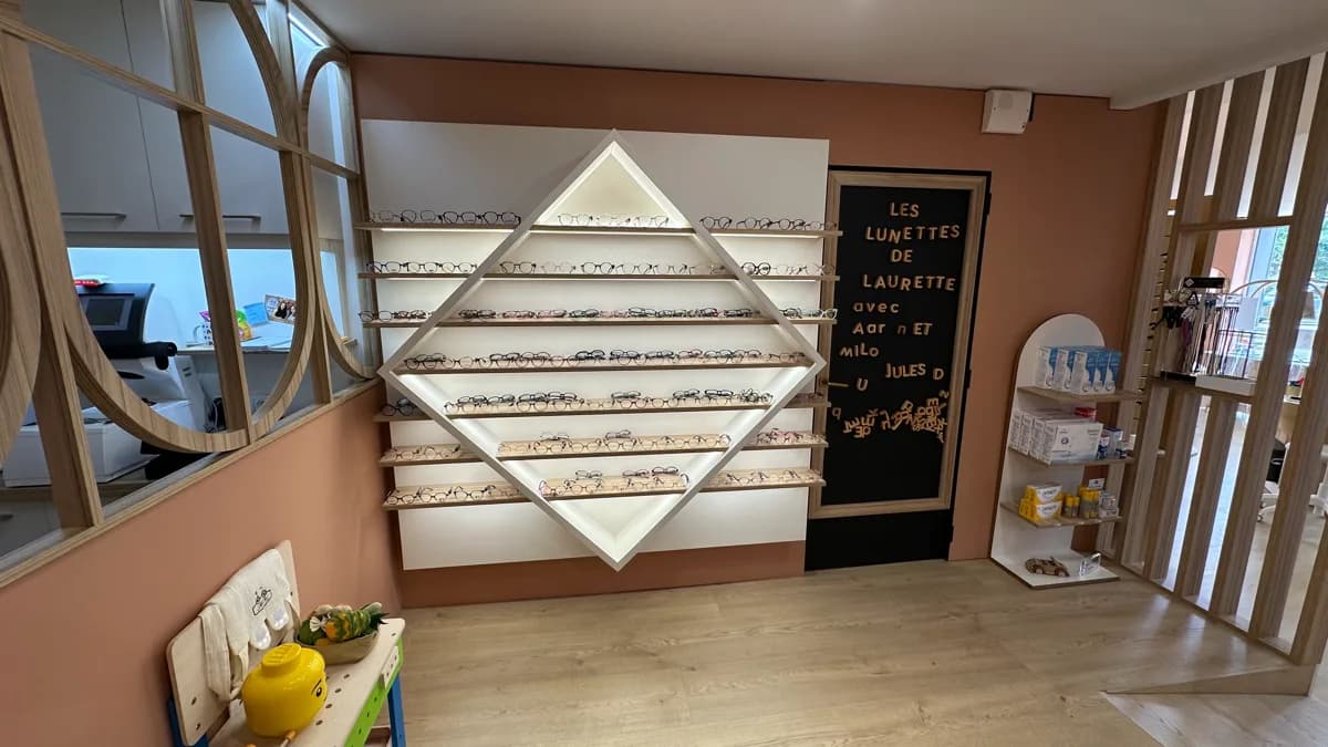 Espace enfant avec mur de montures en losange et ardoise