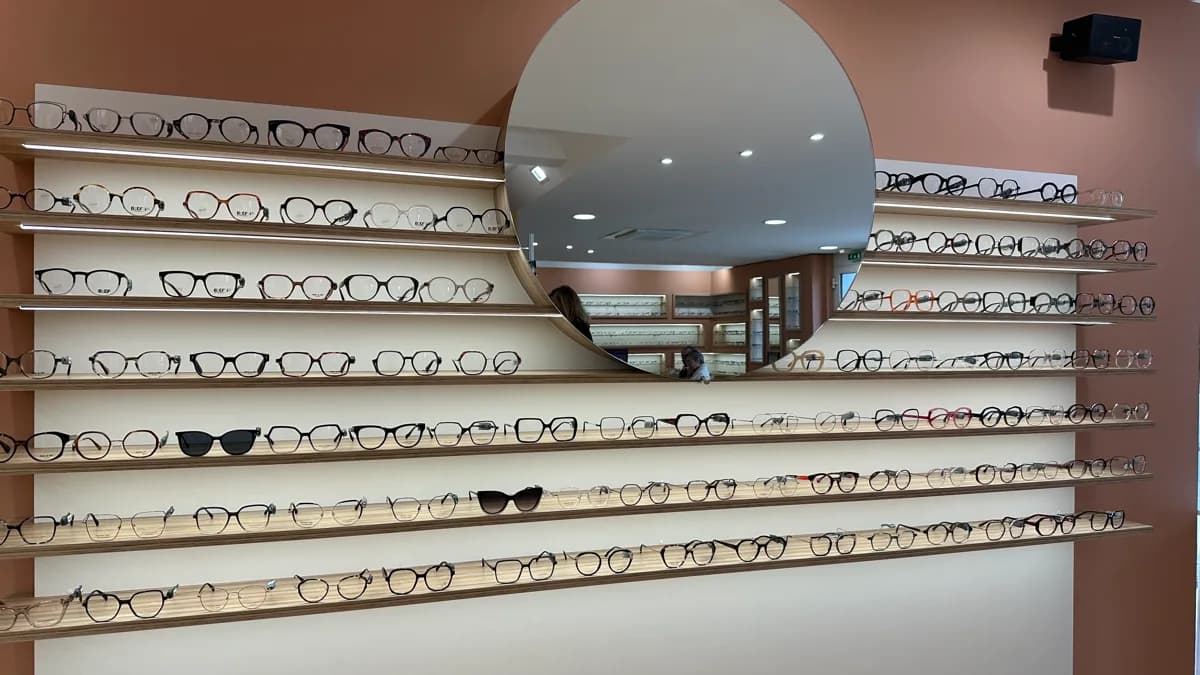 Mur de montures avec miroir rond dans la boutique de Brienne